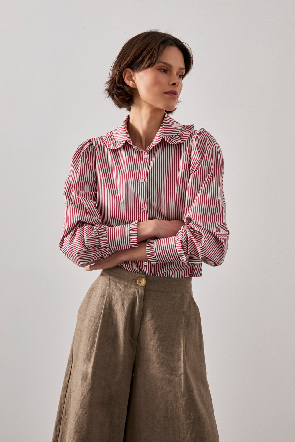 Camisa de manga larga en rayas rojas con pequeño volante en cuello y puños.