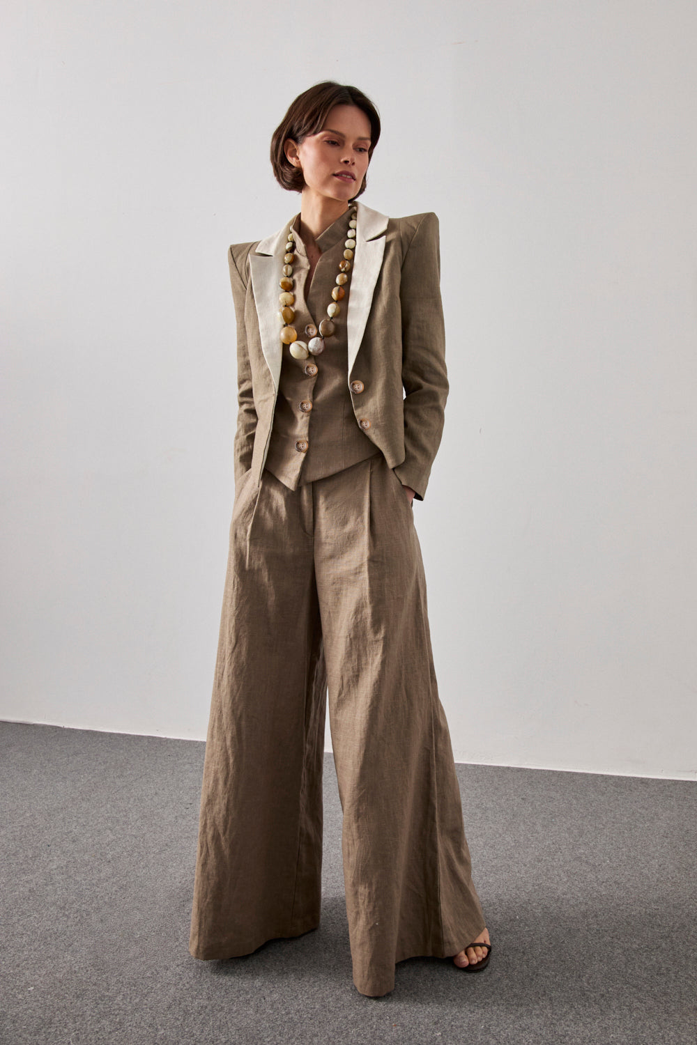 Chaqueta con hombreras en color verde caqui y solapa a contraste en color crema. Está forrada y se cierra con dos botones en el delantero.