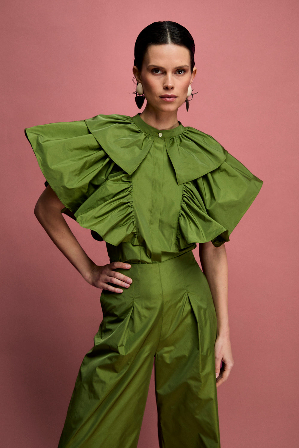 Pantalón de talle alto confeccionado en tafeta en color carmín. Este pantalón es tobillero y tiene pinzas en el delantero.