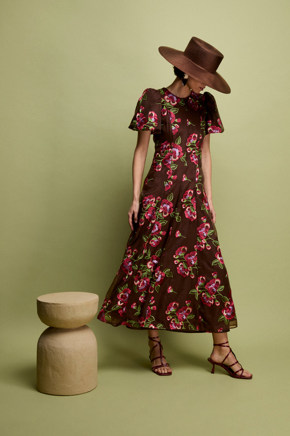 Vestido midi confeccionado en organza marrón con flores bordadas. Tiene cuello a la caja y manga corta abullonada.