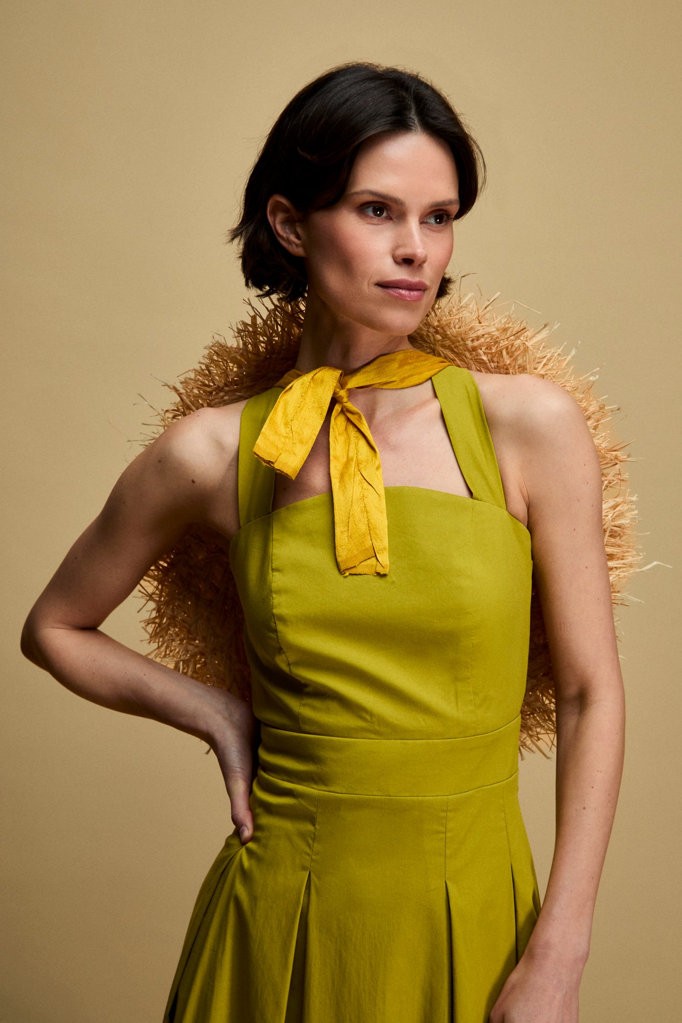 Vestido Anine Pistacho de Vogana para invitada de boda verano 2026 con tirantes cruzados por la espalda, cintura marcada y falda tableada