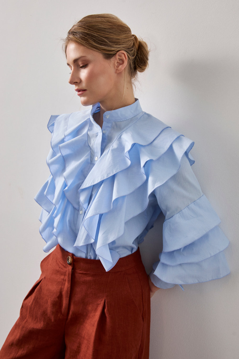 Camisa celeste de manga larga con volante en pecho y espalda. 