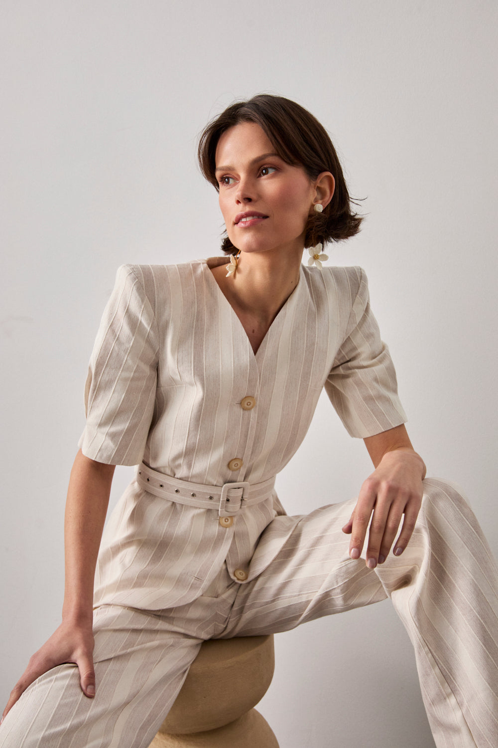 Chaqueta entallada de rayas en color crema. Esta chaqueta tiene manga corta con hombros estructurados y escote en uve.