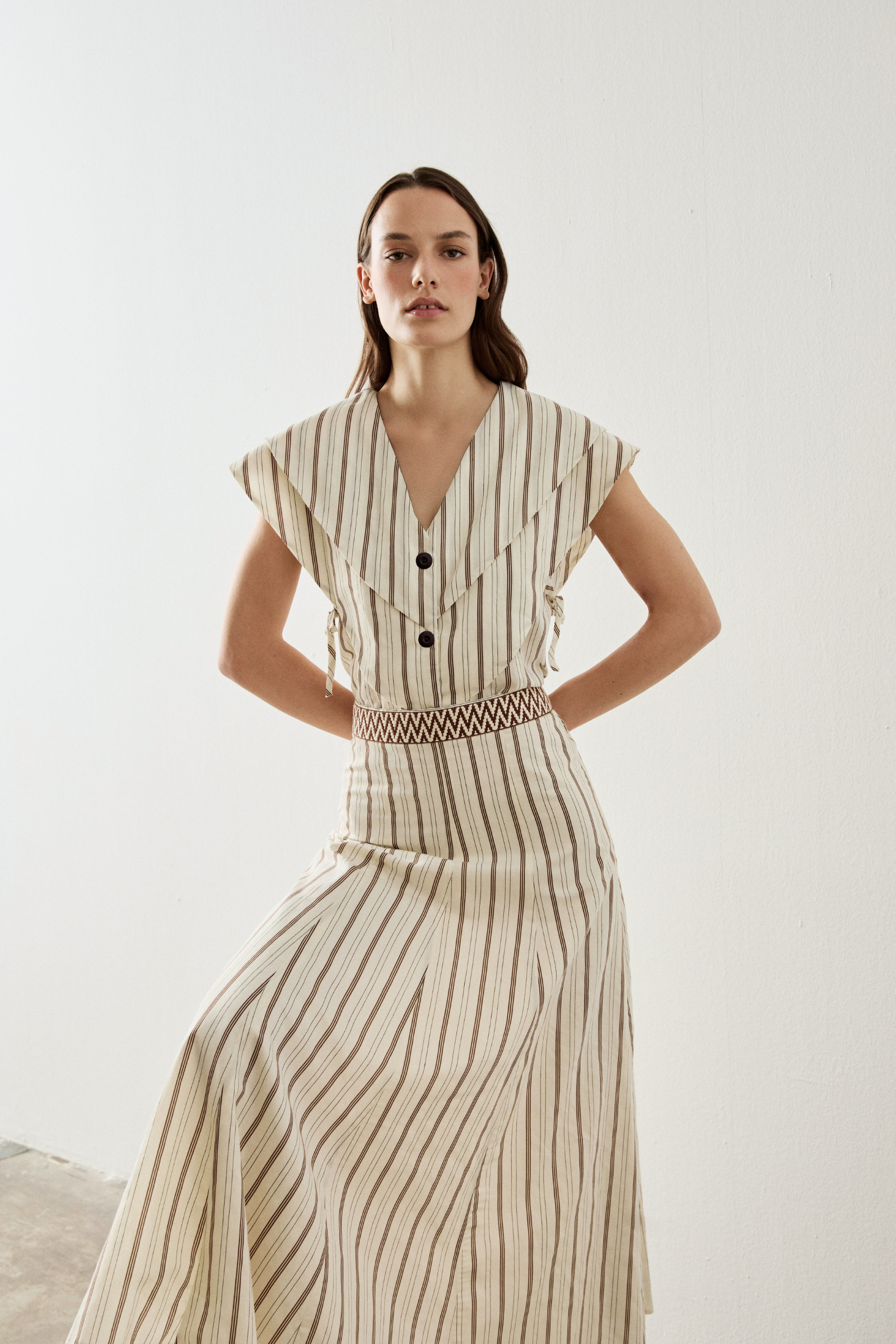 Falda midi de rayas en color crema. Esta falda tiene tiro alto con corte evasé y detalle en cinturilla con dibujo geométrico