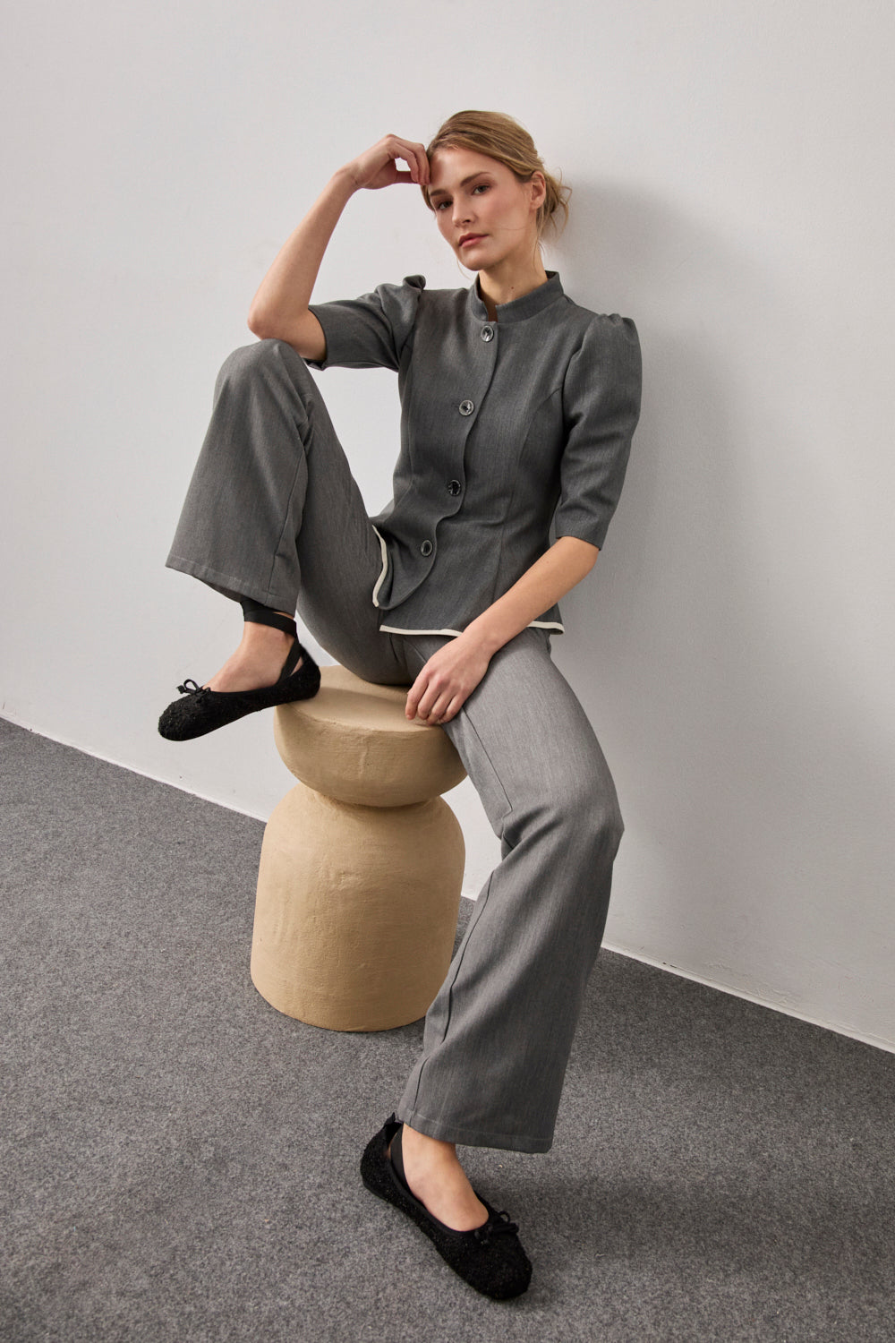 Pantalón de pinzas y pernera recta en color gris.Cuenta con bolsillos delanteros y cierre con botón.