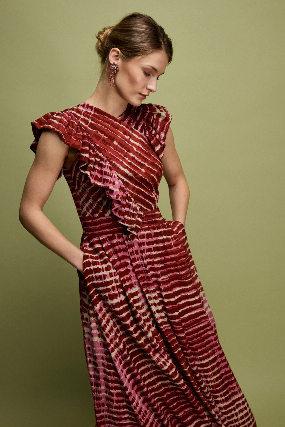 Vestido midi en color fresa con volante en hombros. Este vestido tiene falda tableada con cinturilla e incluye bolsillos. 